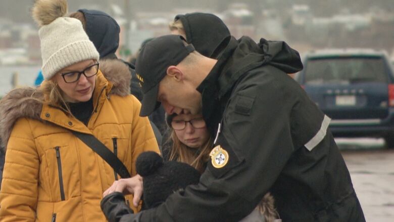 Family members hug one another.