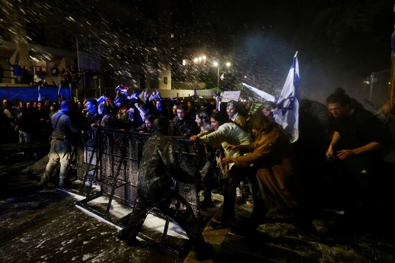 A water cannon is used as police clash with protesters.