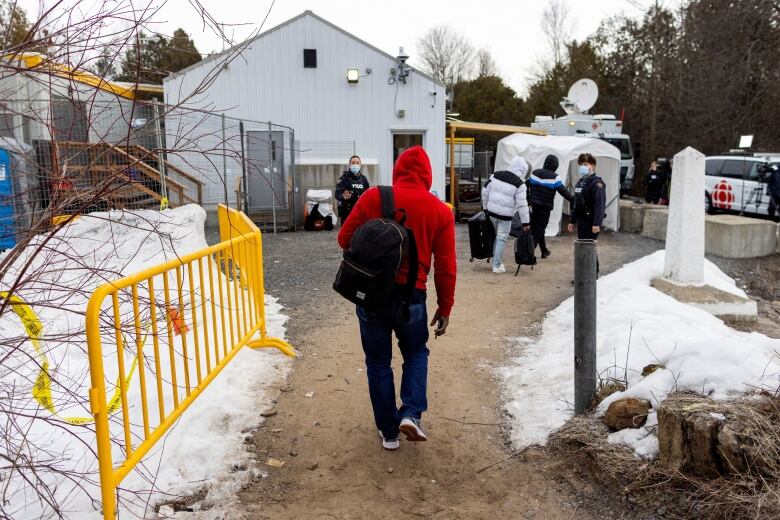 Olivier Nanfah crosses into Canada at Roxham Road, an unofficial crossing point from New York State to Quebec for asylum seekers, in Champlain, New York, U.S. March 25, 2023. REUTERS/Carlos Osorio