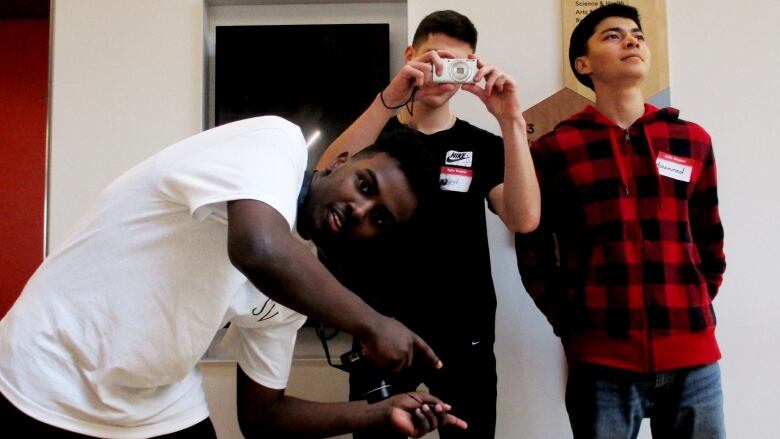 Three young men pose for the camera.