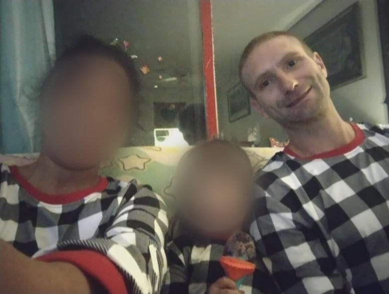 A woman, child and man pose for a family photo in matching pyjamas.