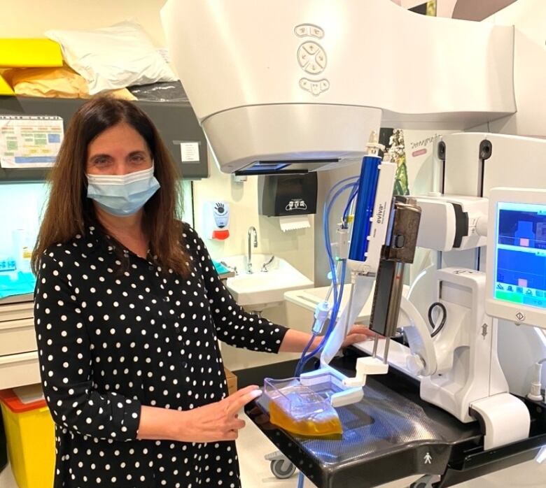 Dr. Anat Kornecki stands next to a biopsy machine.