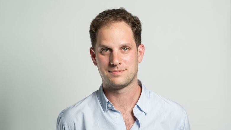 A man in a collared shirt is shown posing for a photo.