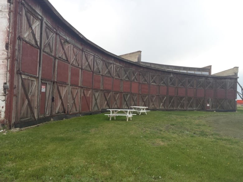 A circular roundhouse with picnic tables sitting out front.