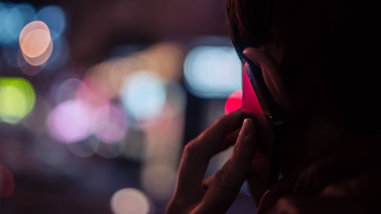 a man holding a phone at night