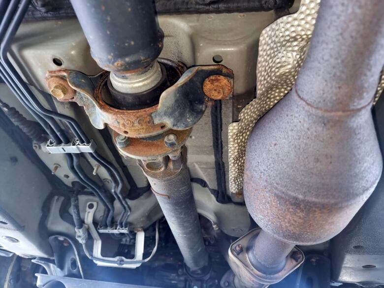 A catalytic converter is pictured underneath a vehicle.