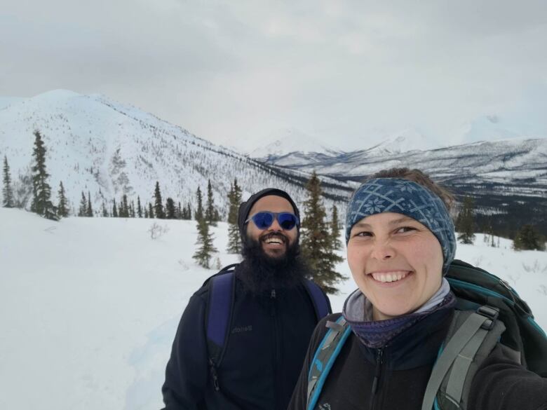 Man and woman standing outside in the snow.