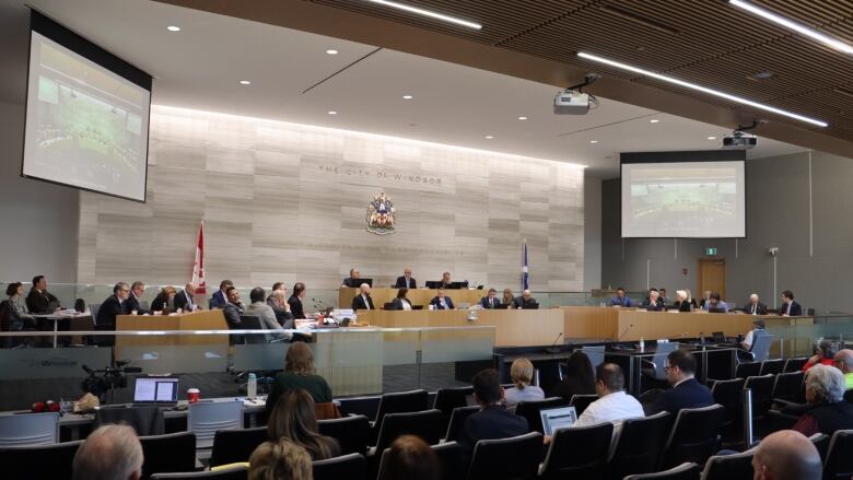 City councillors in chambers, with an audience.