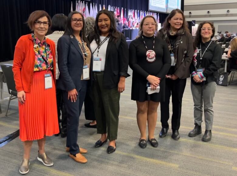 Six women stand in a row the AFN assembly.