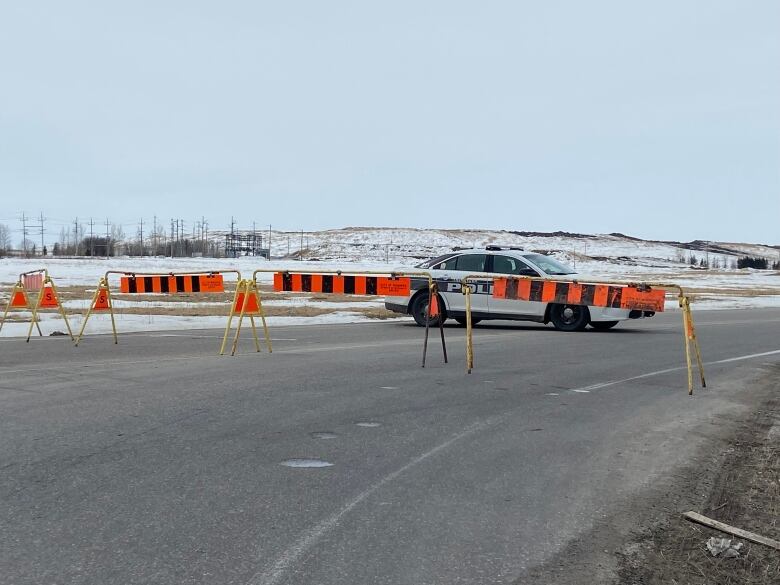 A Winnipeg police car was seen behind barricades set up by Brady Landfill in Winnipeg on Tuesday.