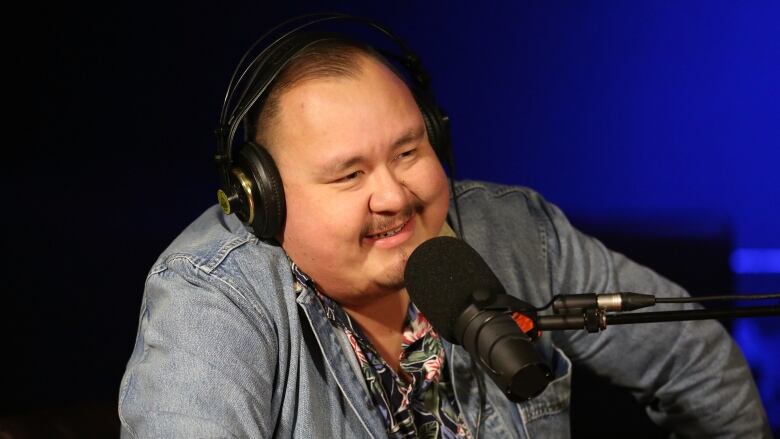 William Prince sitting in front of a microphone, wearing headphones.