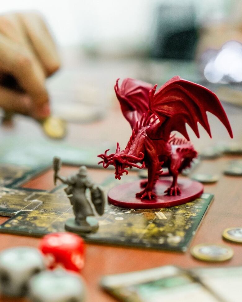 closeup of a dungeons & dragons game board with a red dragon piece in the centre