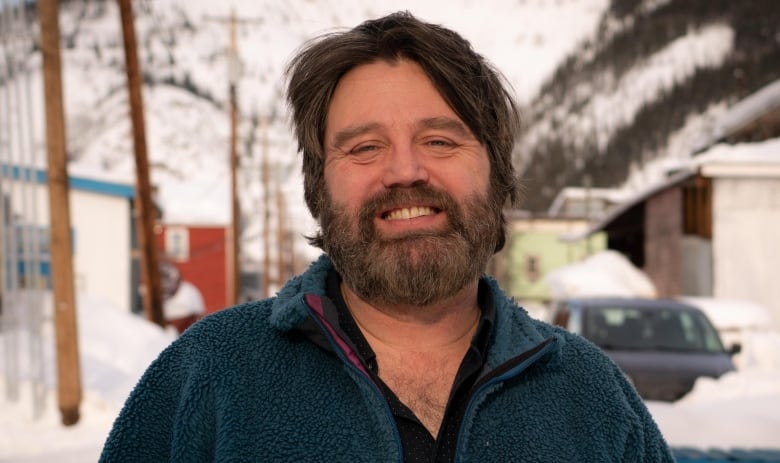 A smiling man standing outside 