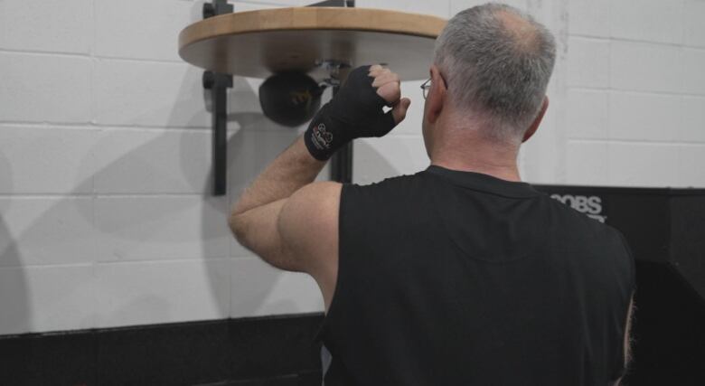 A man punches a speed bag.