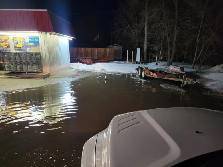 A gas station parking lot appears flooded.