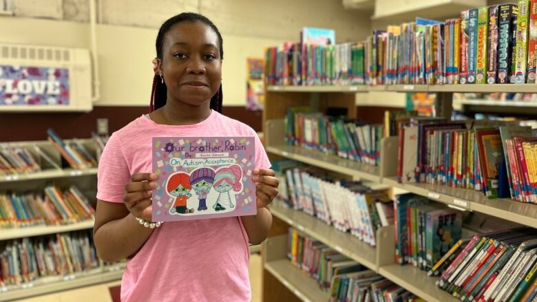 teenager holding book and smiling