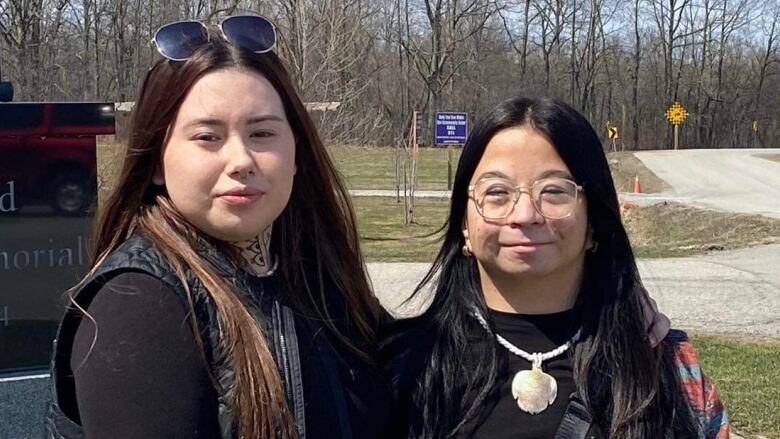 Two teenage girls pose together outside Six Nations Community Hall.