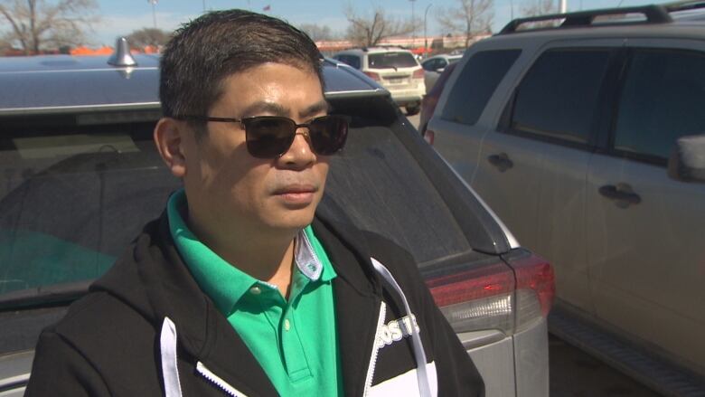 A man in sunglasses and a green shirt.