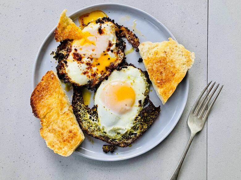 Eggs and toast sit on a plate.