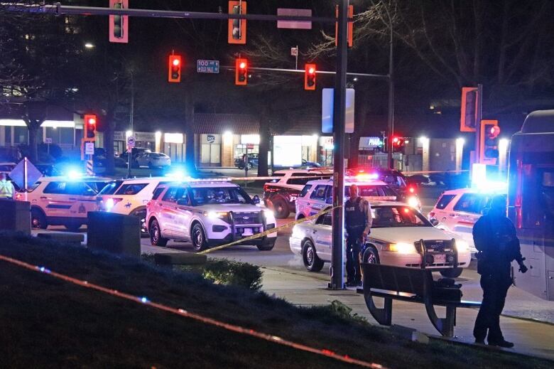 Flashing police cars are pictured on a taped-off intersection.