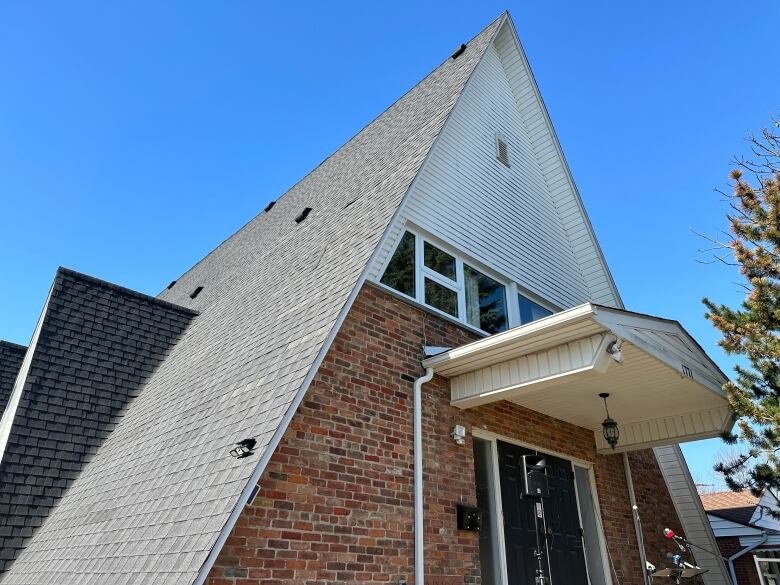 A roof reaches into a blue sky.