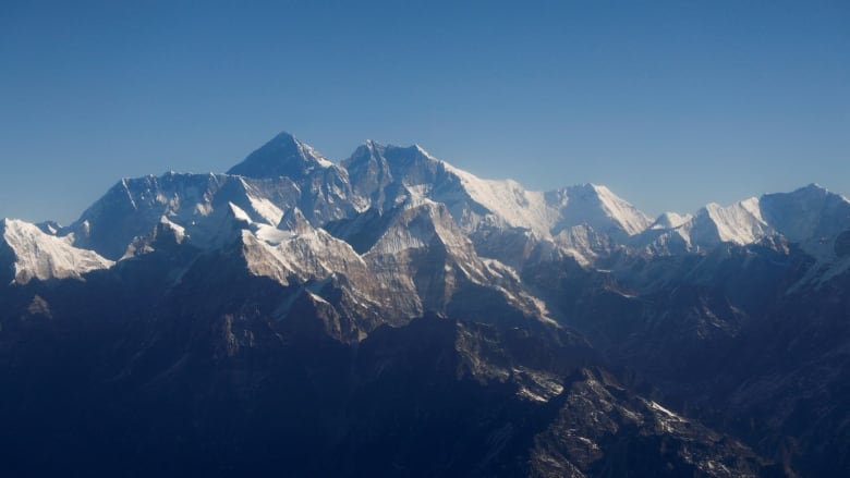 A mountain range is shown under a blue sky.