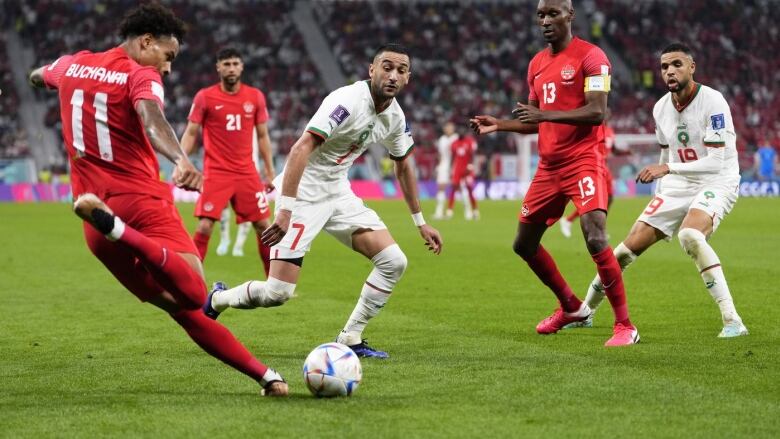 Canada's Tajon Buchanan, left, clears the ball in front Morocco's Hakim Ziyech during World Cup soccer action against Morocco in Doha, Qatar, on Dec. 1, 2022. 