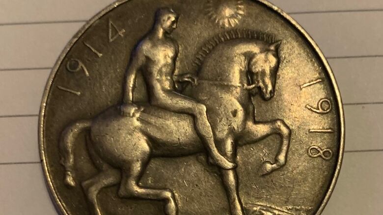 A golden medal with an image of a man riding a horse