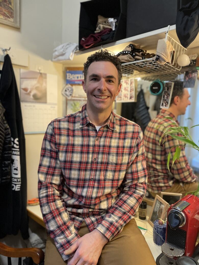 An actor smiles while posing for a photo in his dressing room.