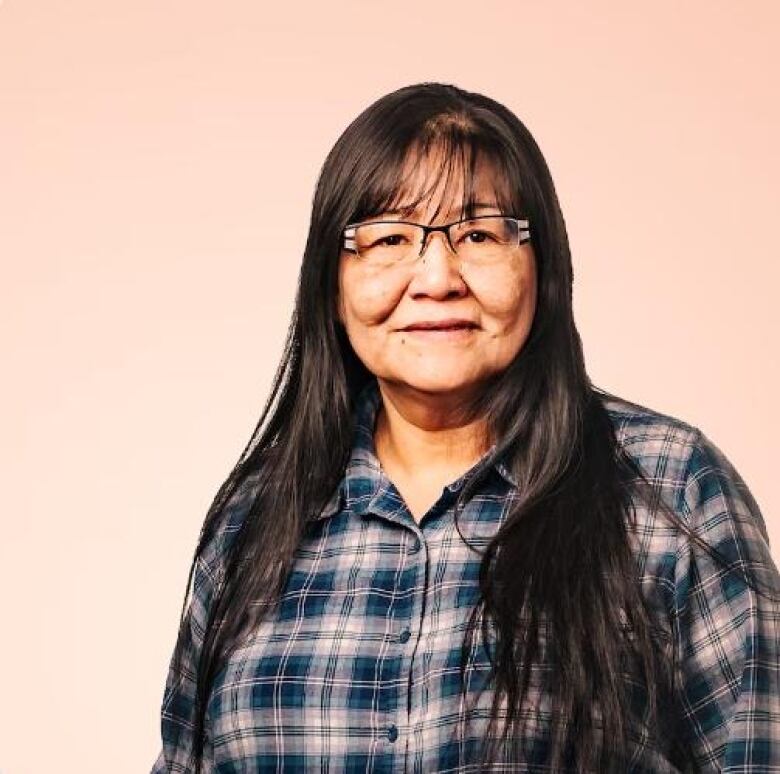 A woman in a blue plaid button up with black hair.