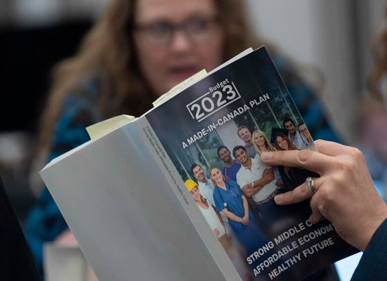 A reporter reads a copy of the latest federal budget.