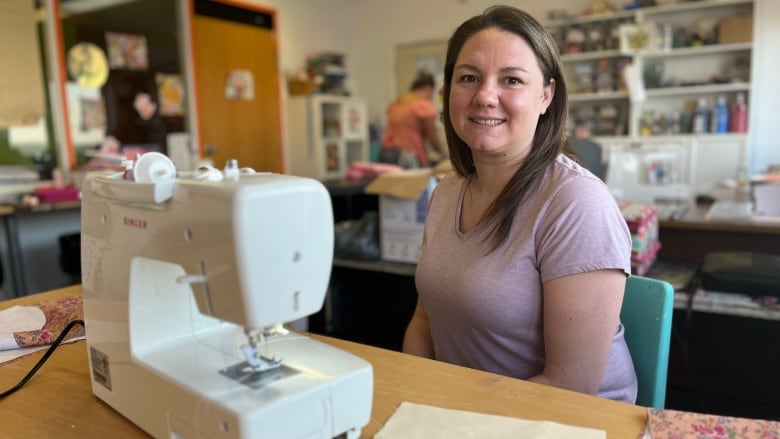 Robin Guyer sitting by a sewing machine.