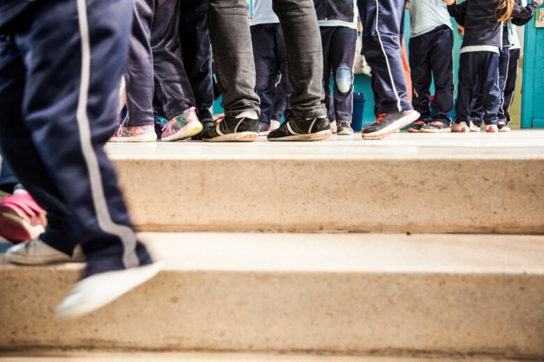 Children's feet in a school hallway.