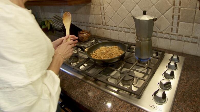 a woman cooking at her gas stove