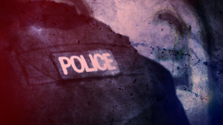 The word police, written in white, uppercase letters, is seen on the back of an officer's black jacket.