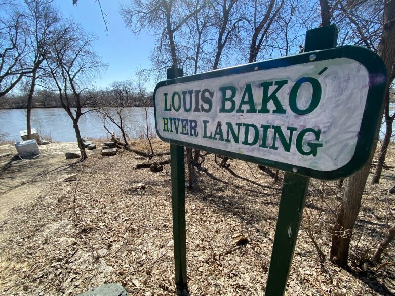 A sign reading 'Louis Bako River Landing' is seen next to a river.