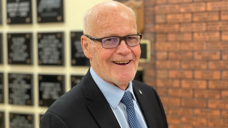 A man in a suit and tie and glasses.