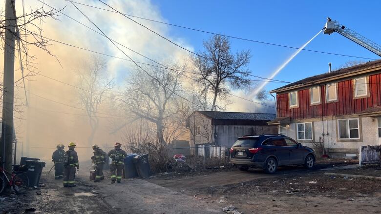 Fire crews look on during a structure fire.