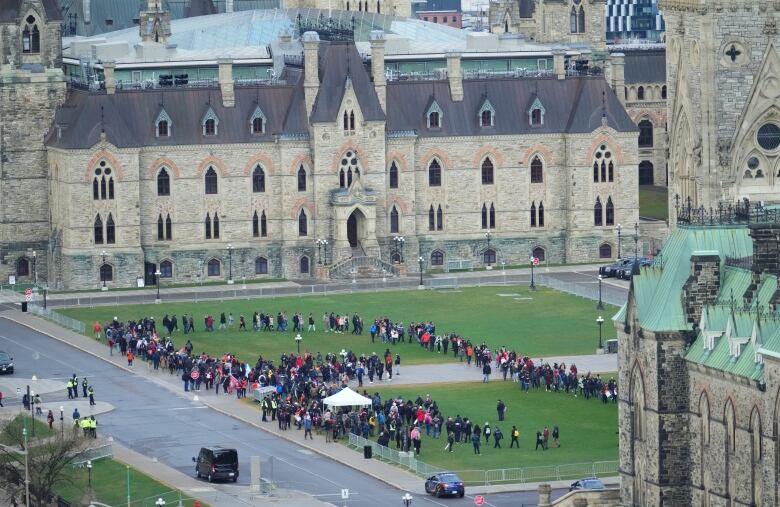 A ring of people in a rally on a legislature lawn.