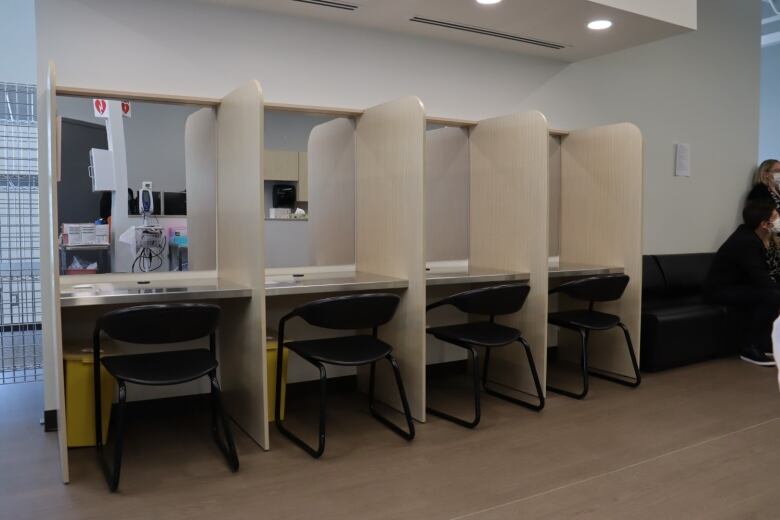 Several booths with chairs behind desks. 