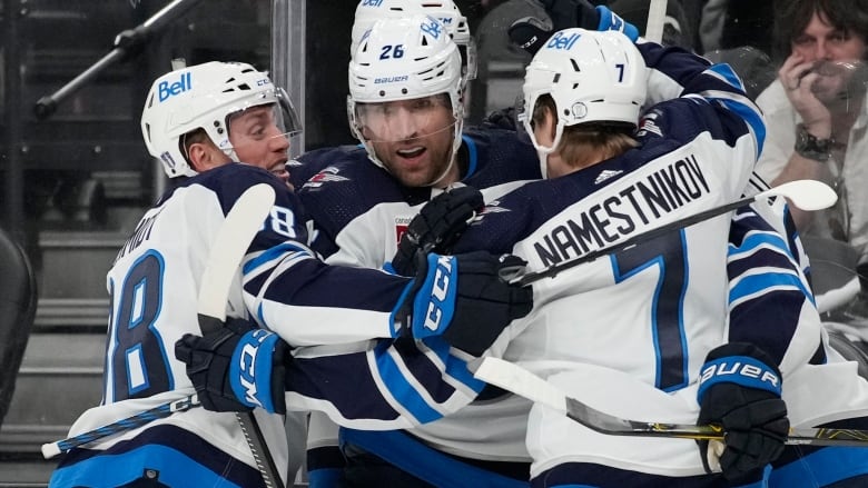 Five Jets players hug in celebration.