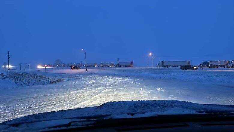 Many semi-trucks in traffic in winter conditions on the highway