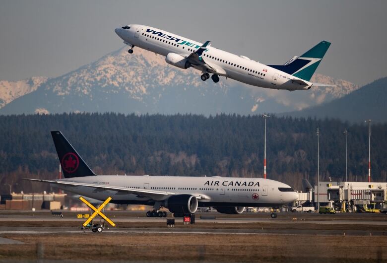 Two planes at an airport - one on the tarmac, one in flight.