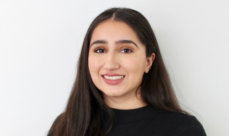 Portrait of smiling young woman with long dark hair.