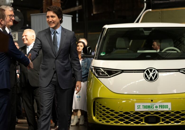 Prime Minister Justin Trudeau looks at Volkswagen car during at tour of St. Thomas, Ont.