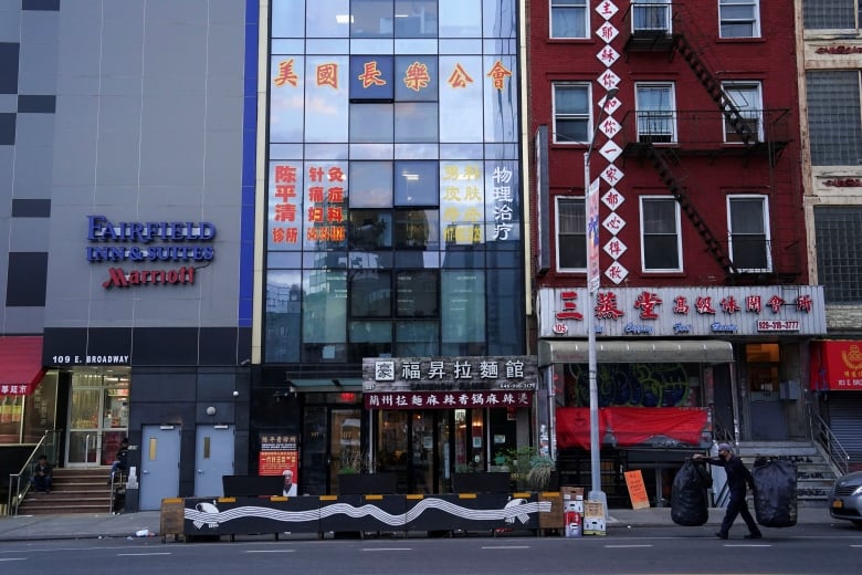 A row of connected midrise buildings with Chinese lettering on them in Manhattan.