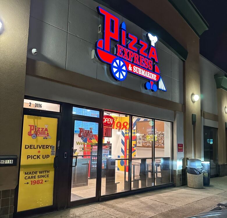 The front of a restaurant with an illuminated sign reading 