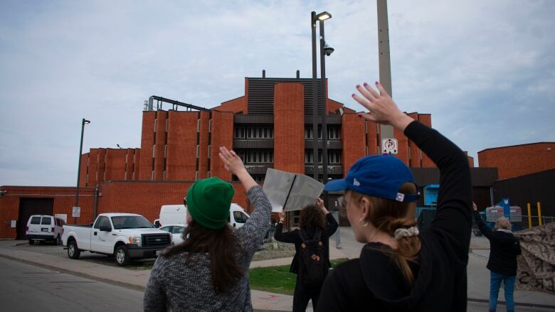 People waving at a prison.