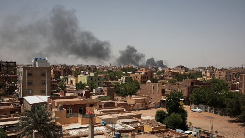 Smoke rises above a city.