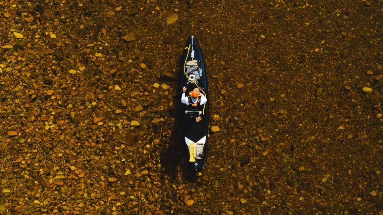 A birds eye view of a person in a canoe in the Margaree River